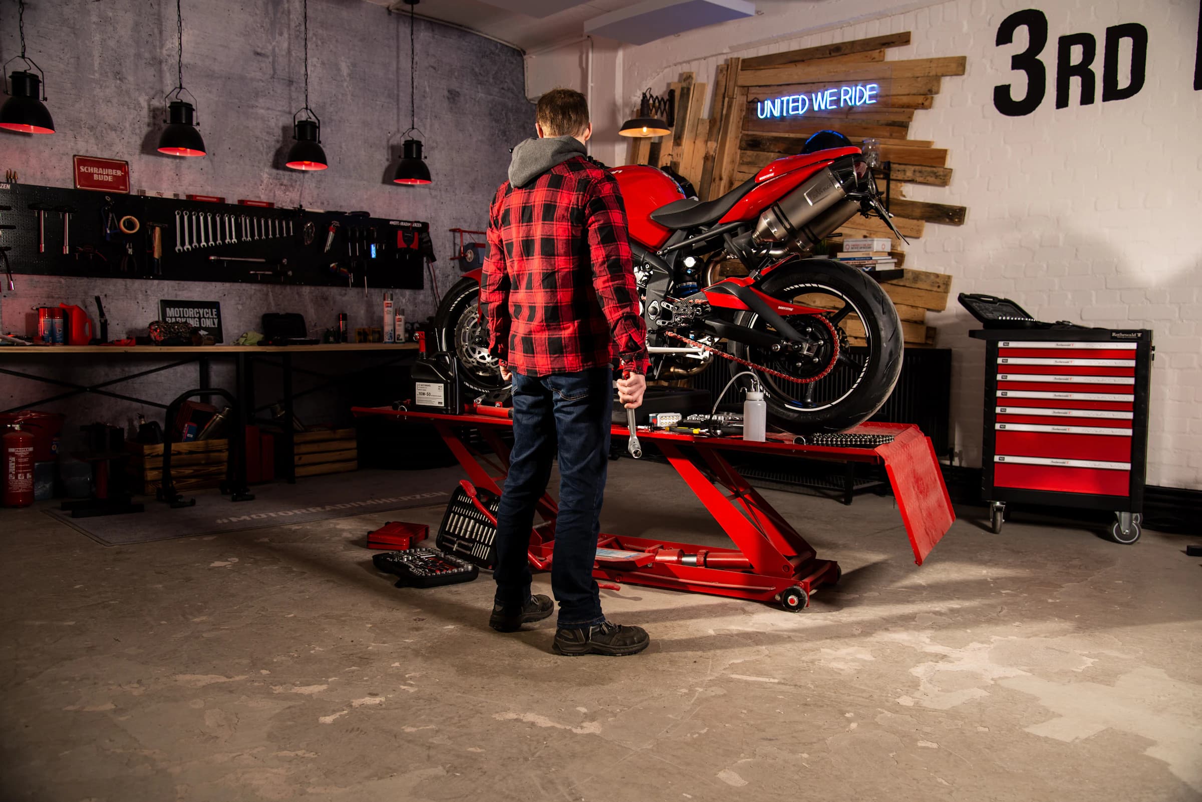 Motorcycle mechanic servicing a bike in a workshop
